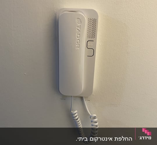 אינטרקום לבן מותקן על קיר